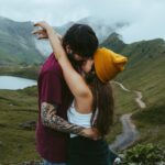 A couple holds each other during their couples session in Switzerland. The girl holds her arms around her boyfriend's neck as he has his hands on her waist and is leaning in to kiss