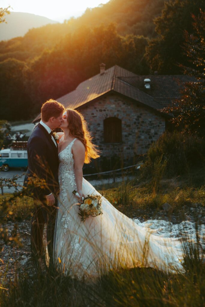 During their elopement in Switzerland, a couple kisses in front of the mountains during golden hour