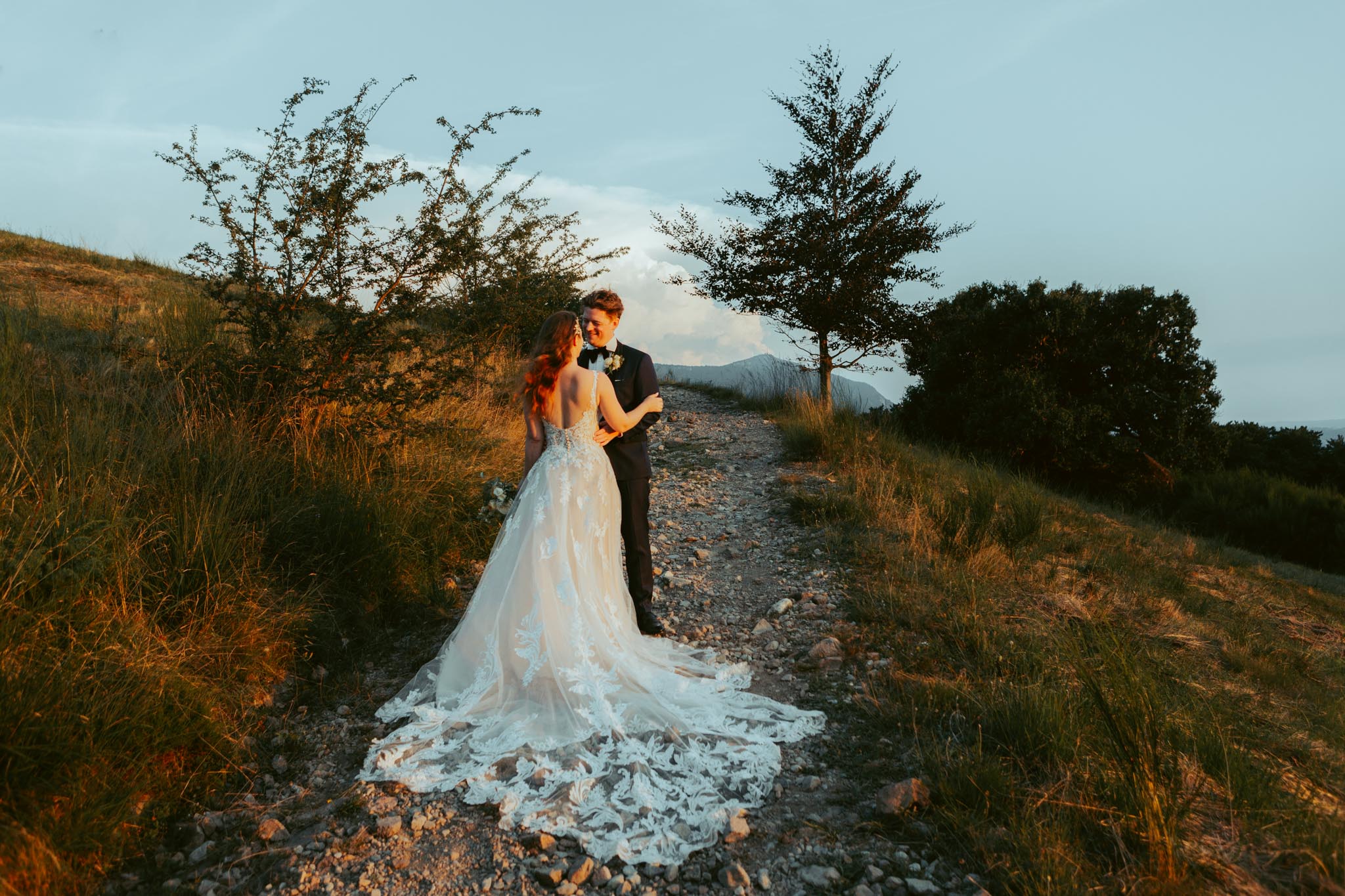 During their elopement in Switzerland, a couple stands in the Alps during golden hour for their portraits 
