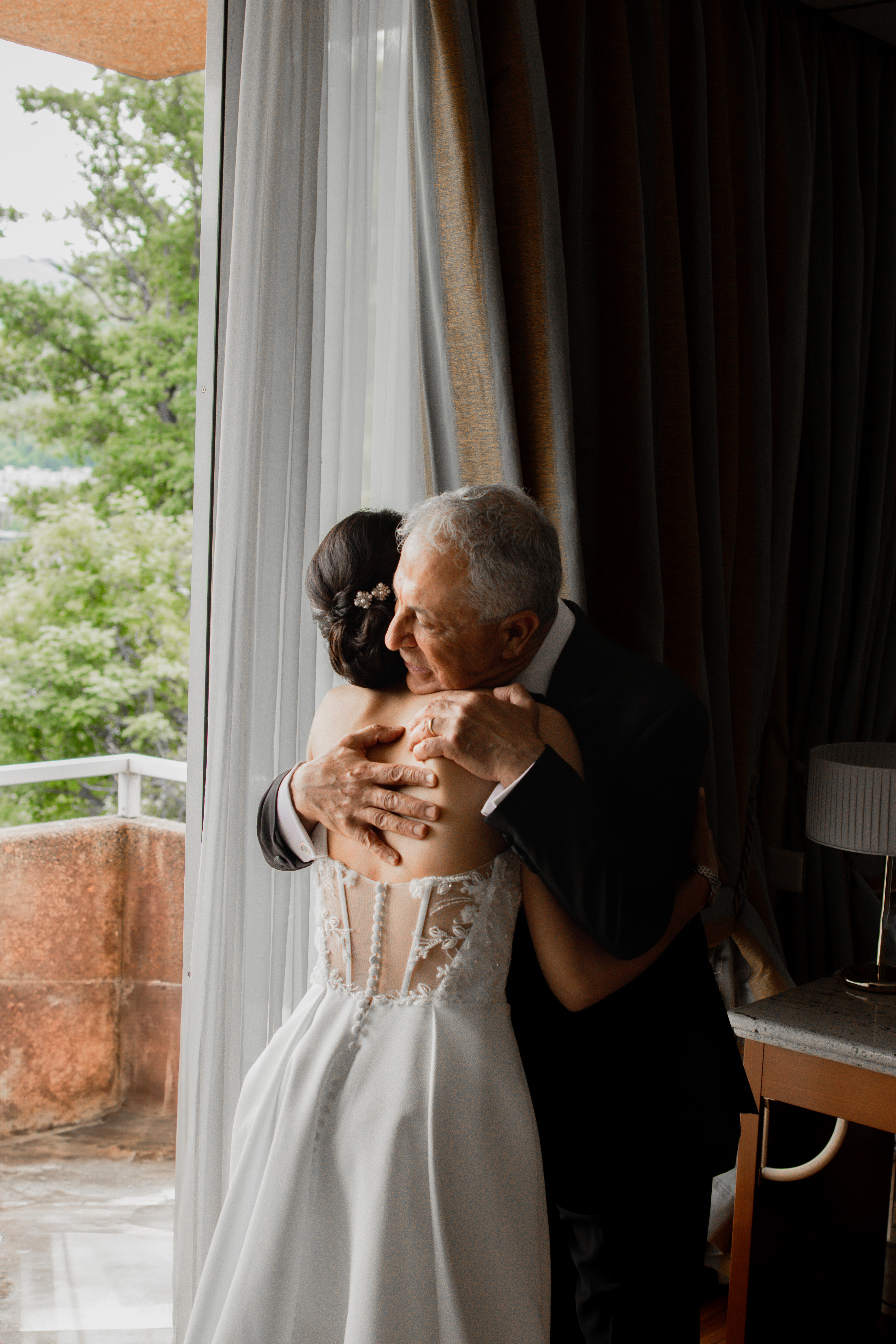 A bride and her father hug during her wedding