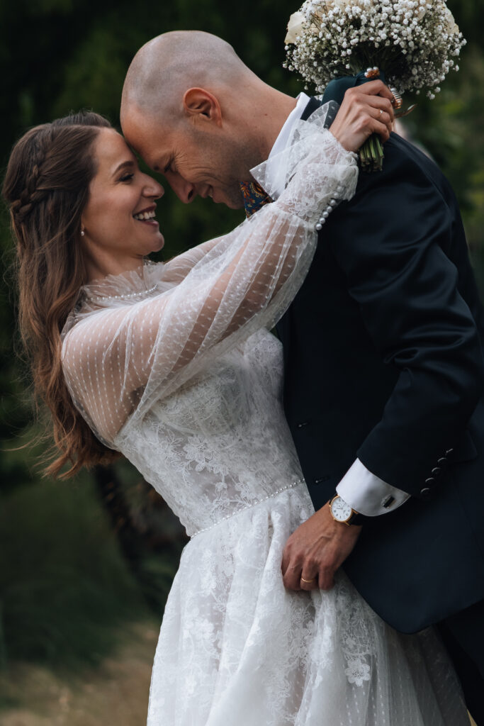 During their elopement Switzerland, a couple embraces and touches foreheads in a beautiful mountain meadow