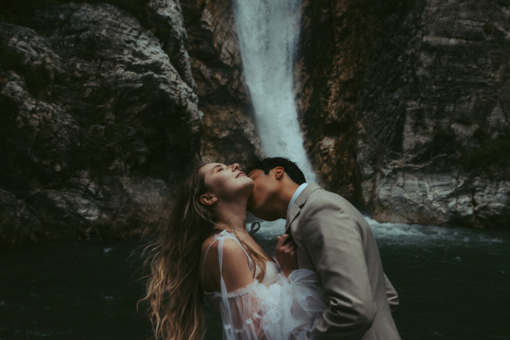 A couple elopes in Switzerland, during which the groom kisses his bride on the neck as she leans back, her hair flowing in the wind