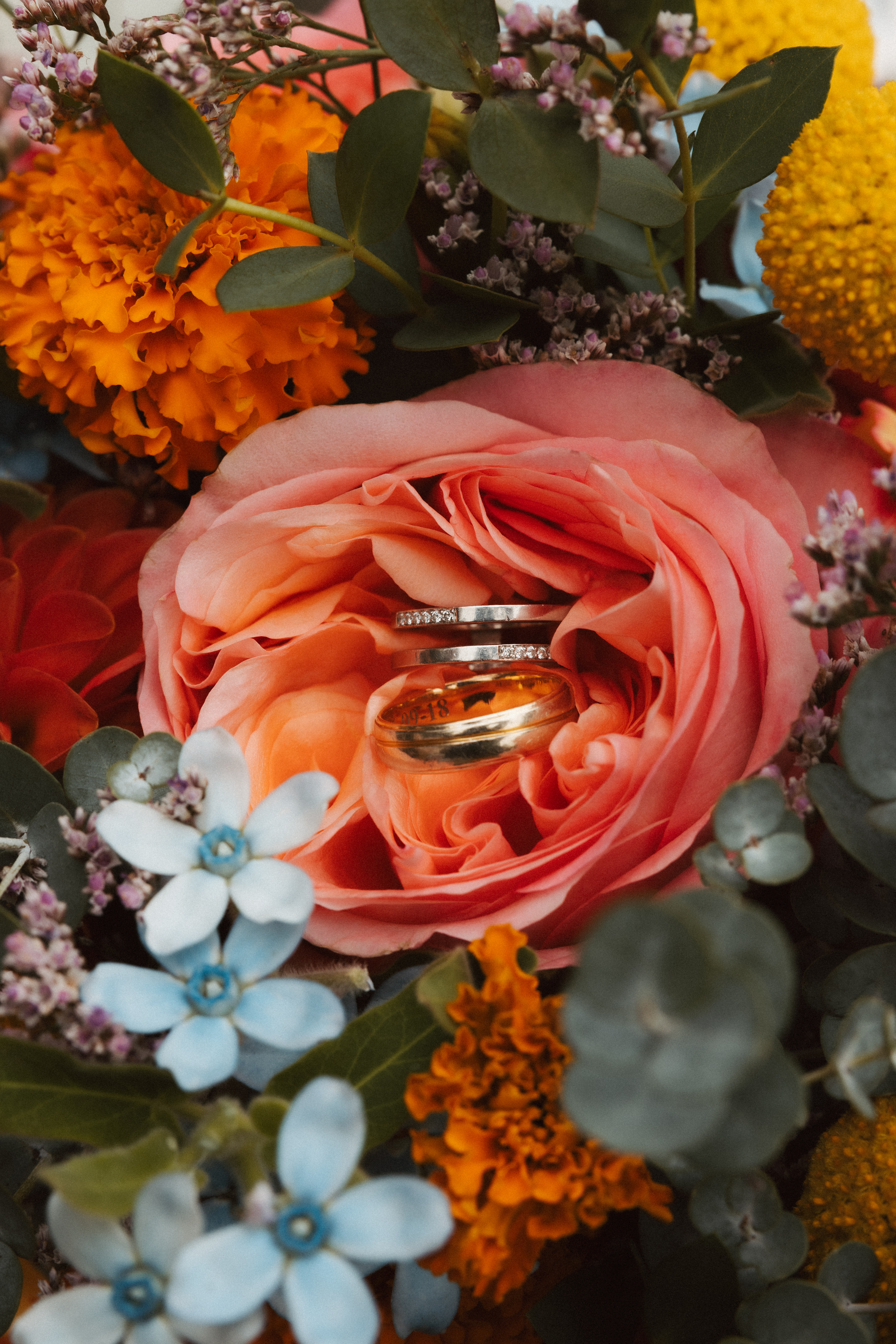 two wedding bands lie in a flower bouquet during a swiss wedding