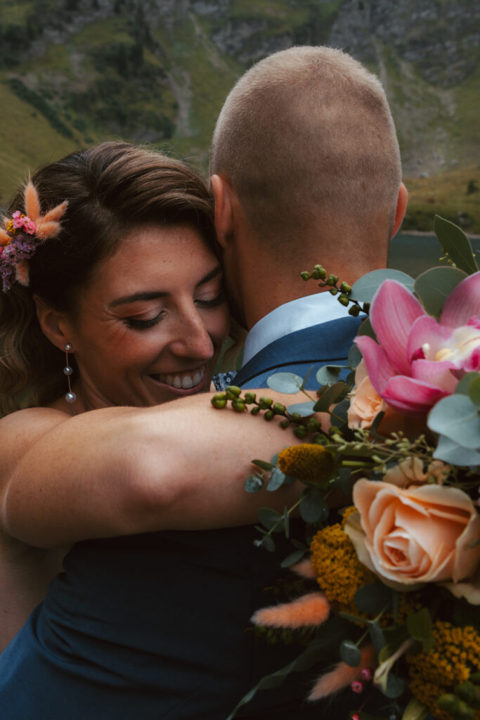 Close up photo of a couple embracing during their elopement in Switzerland in front of a mountain lake
