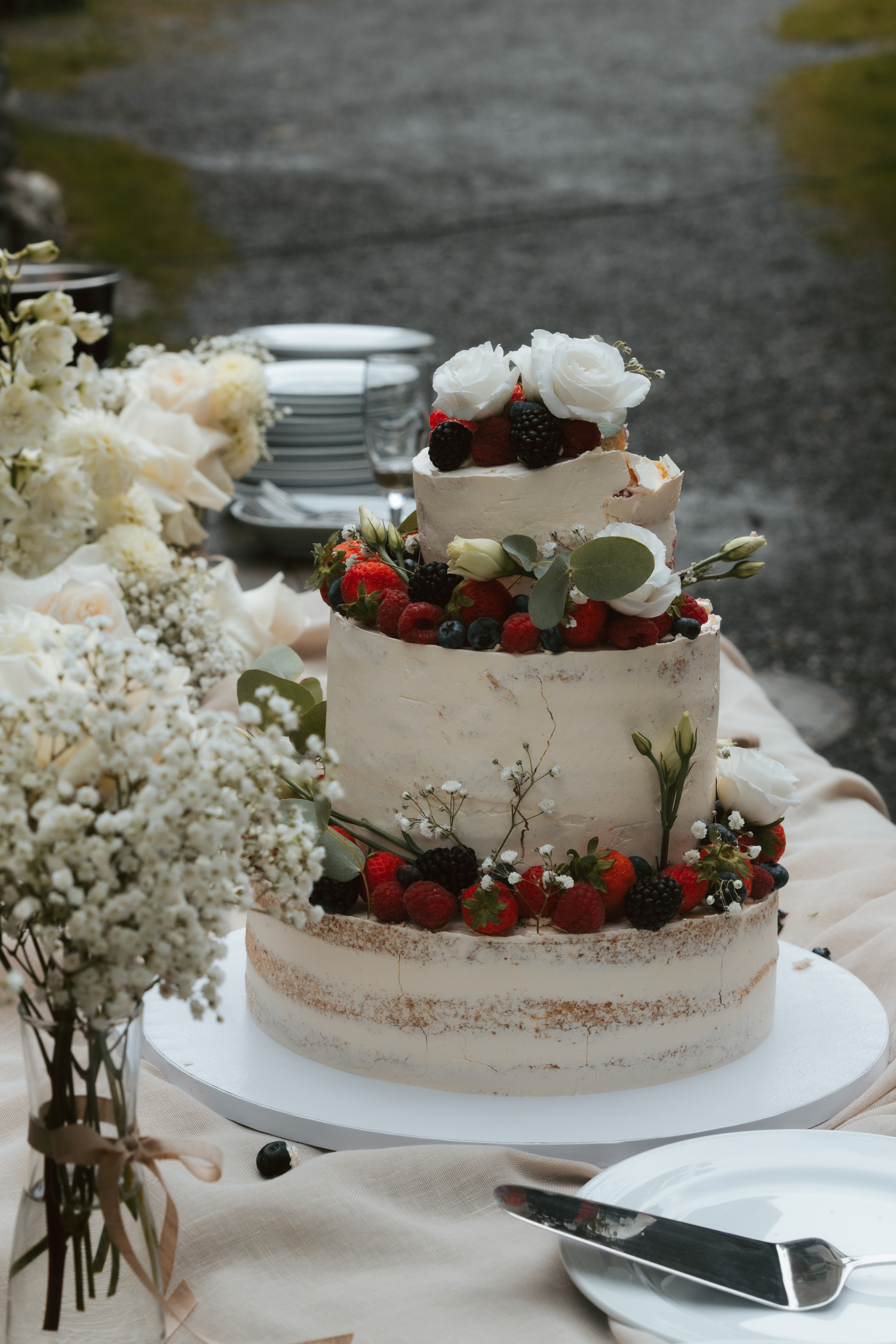Close up of a wedding cake with berries and white flowers