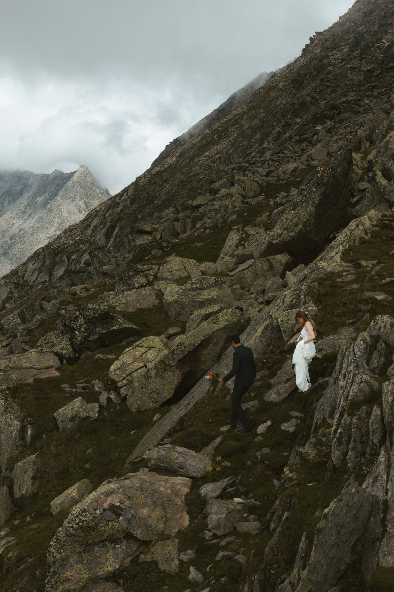 A couple hikes on a mountain ridge during their elopement in Switzerland