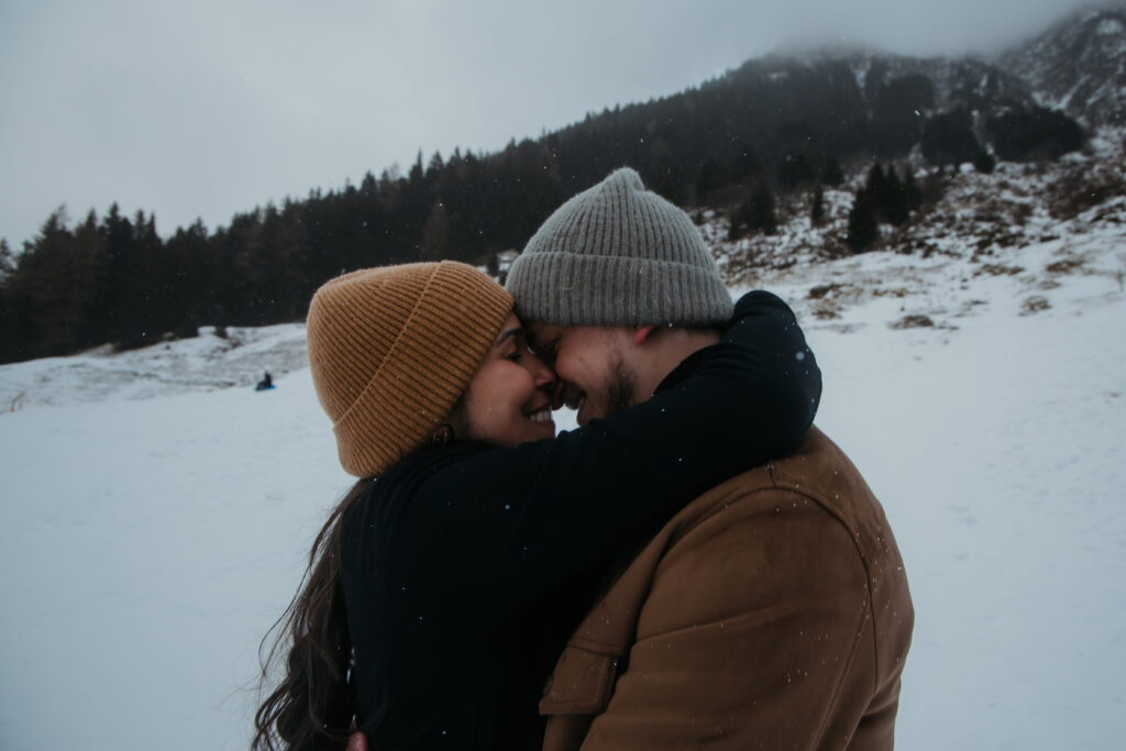 Profiles of a couple embracing in the snow on a mountain in Andermatt