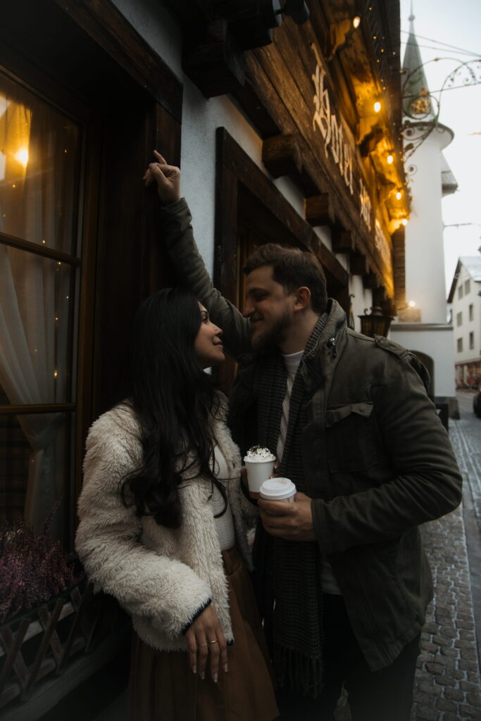 A man leans close to his partner on the streets of Andermatt, Switzerland